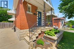Red brick exterior with stone veneer accents, a blue front entry door, and a concrete driveway - 