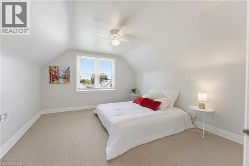Attic room featuring a single window with blinds, sloped ceilings, and light-toned carpeting - 282 East 13Th Street, Hamilton, ON - Indoor Photo Showing Bedroom