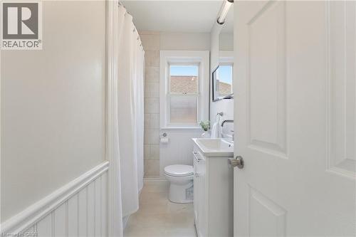 Bathroom featuring a white vanity with an integrated sink, polished chrome faucet, and mirrored medicine cabinet - 282 East 13Th Street, Hamilton, ON - Indoor Photo Showing Bathroom
