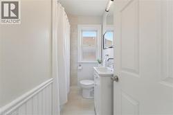 Bathroom featuring a white vanity with an integrated sink, polished chrome faucet, and mirrored medicine cabinet - 