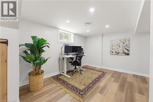 Recessed lighting illuminates this versatile room, featuring a window, paneling on walls, and wood-finish flooring - 282 East 13Th Street, Hamilton, ON - Indoor