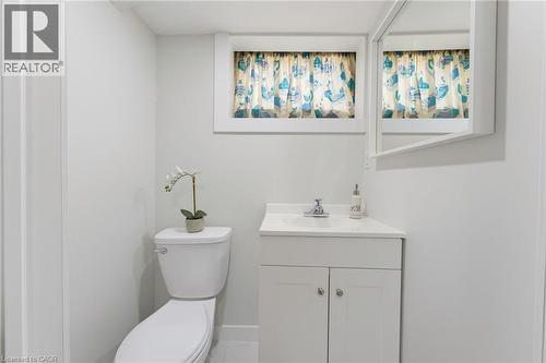 Bright bathroom featuring a white vanity with integrated sink, chrome faucet, and a wall-mounted mirror - 282 East 13Th Street, Hamilton, ON - Indoor Photo Showing Bathroom