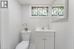 Bright bathroom featuring a white vanity with integrated sink, chrome faucet, and a wall-mounted mirror - 