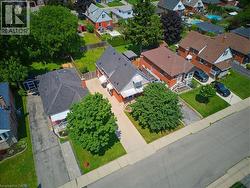 Brick residential property with a dark shingle roof and front awnings - 