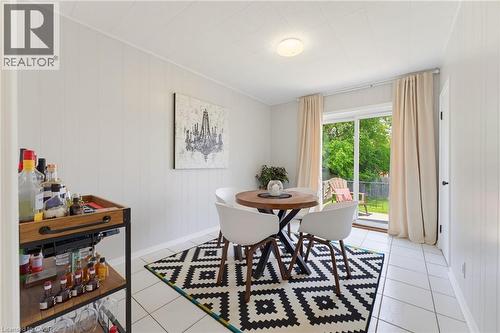 Dining area featuring white tile flooring and vertical wall paneling - 282 East 13Th Street, Hamilton, ON 
