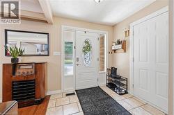 Entryway featuring a white front door with an oval glass insert, flanked by clear sidelights - 