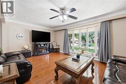 Living area featuring rich wood-finish flooring and a prominent bay window - 