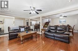 Open-concept living area featuring wood-finish flooring, recessed lighting, and ceiling fans - 