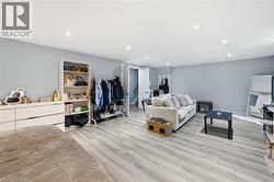Spacious room with light gray walls, wood-finish flooring, and recessed lighting - 