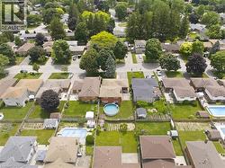 Aerial perspective showcasing a residential neighborhood with diverse housing styles, mature trees, and varied landscaping - 