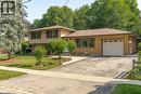 Split-level residence featuring a brick and siding exterior, an attached garage, and a paved driveway - 64 Warren Road, Kitchener, ON 