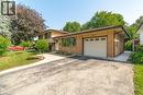 Traditional split-level residence featuring brick and siding exterior, an attached single-car garage with a panel door, and a paved driveway - 64 Warren Road, Kitchener, ON 