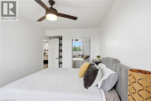 Bedroom featuring a ceiling fan with integrated lighting, white walls, and wood-finish flooring - 15 Nicklaus Drive Unit# 17, Hamilton, ON 