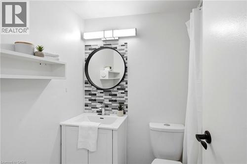Contemporary vanity featuring an integrated sink, polished chrome faucet, and a mosaic tile backsplash - 15 Nicklaus Drive Unit# 17, Hamilton, ON 