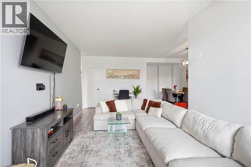 Open-concept living space featuring wood-finish flooring, light grey walls, and recessed lighting - 15 Nicklaus Drive Unit# 17, Hamilton, ON 