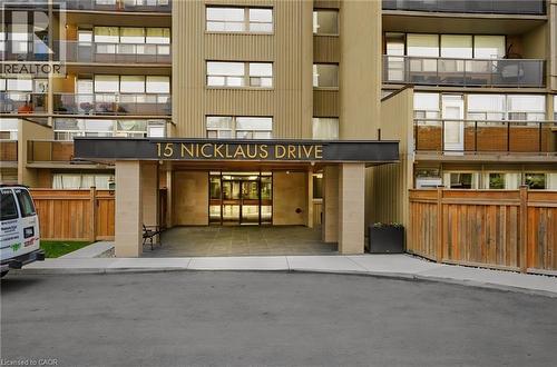 Building entrance featuring a covered portico, prominent signage, and an automatic revolving door - 15 Nicklaus Drive Unit# 17, Hamilton, ON 