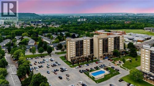 Aerial perspective showcasing a multi-building residential complex with expansive parking areas - 15 Nicklaus Drive Unit# 17, Hamilton, ON 