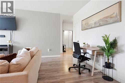 Open concept living space featuring light wood-finish flooring, a neutral color palette, and a built-in desk area - 15 Nicklaus Drive Unit# 17, Hamilton, ON 