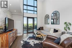 Two-story window wall with glass doors opening to an outdoor patio - 