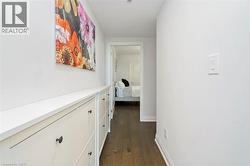Hallway featuring dark wood-finish flooring and light wall paint - 
