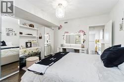 Bedroom featuring wood-finish flooring and a decorative overhead light fixture - 