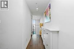 Bright hallway featuring recessed lighting and dark wood-finish flooring - 