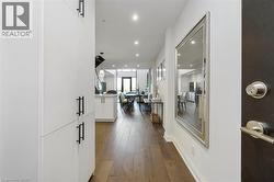 Entryway featuring wood-finish flooring, white walls, and recessed lighting - 