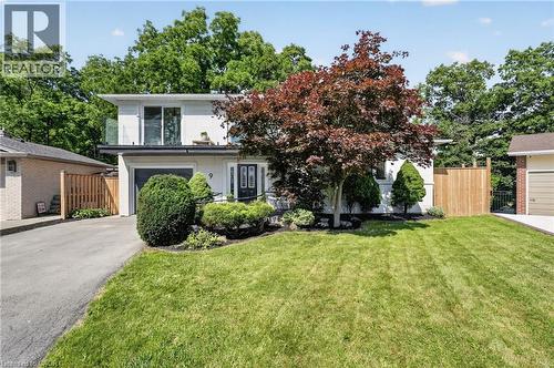 Split-level residence featuring a single-car garage, mature front yard landscaping with a prominent tree, and a second-story balcony with a glass railing - 9 Leslie Drive, Hamilton, ON - Outdoor