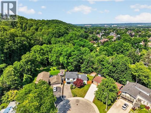 Aerial perspective showcasing a residential cul-de-sac with surrounding mature trees and distant urban landscape - 9 Leslie Drive, Hamilton, ON - Outdoor With View