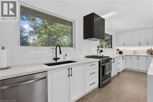 Modern kitchen featuring white shaker cabinetry, light-toned countertops, and a full tile backsplash - 9 Leslie Drive, Hamilton, ON - Indoor Photo Showing Kitchen With Upgraded Kitchen