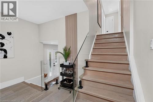 Light wood-finish staircase with clear glass railing - 9 Leslie Drive, Hamilton, ON - Indoor Photo Showing Other Room