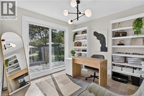 Room featuring wood-finish flooring, a modern chandelier with spherical lights, and light gray wall paint - 9 Leslie Drive, Hamilton, ON - Indoor