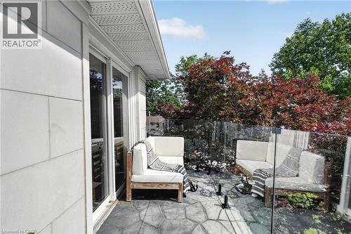 Private balcony featuring a glass railing, stamped concrete flooring, and a sliding glass door - 9 Leslie Drive, Hamilton, ON - Outdoor With Deck Patio Veranda