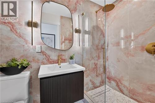 Bathroom featuring patterned wall tiles, a glass-enclosed shower, gold-toned fixtures, a contemporary vanity, and a frameless mirror - 9 Leslie Drive, Hamilton, ON - Indoor Photo Showing Bathroom