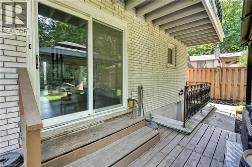 Rear exterior featuring a brick facade, sliding glass doors, a wood deck, and a fenced perimeter - 9 Leslie Drive, Hamilton, ON - Outdoor With Deck Patio Veranda With Exterior