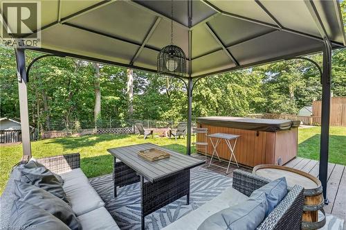 Expansive outdoor living area featuring a covered gazebo, hot tub, and wood-finish decking - 9 Leslie Drive, Hamilton, ON - Outdoor