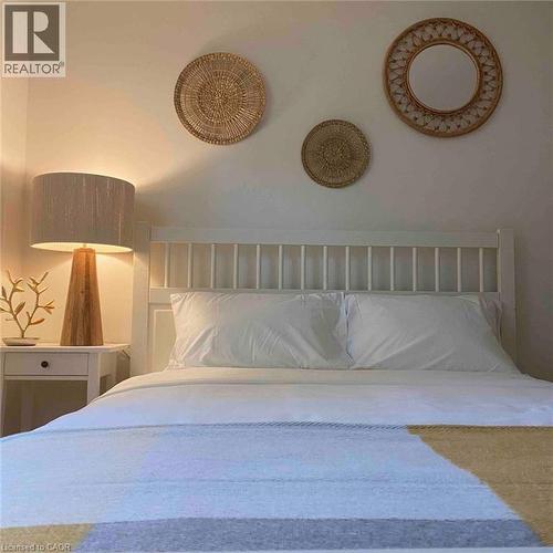 White painted spindle headboard, white bedside table with single drawer, and recessed wall lighting - 919 Montgomery Drive, Ancaster, ON 