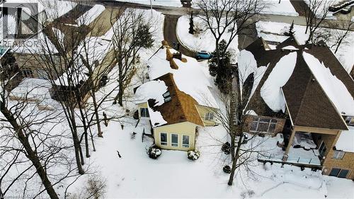 Residential property featuring a light-colored exterior, brown shingled roof, and a prominent sunroom with multiple windows - 919 Montgomery Drive, Ancaster, ON 