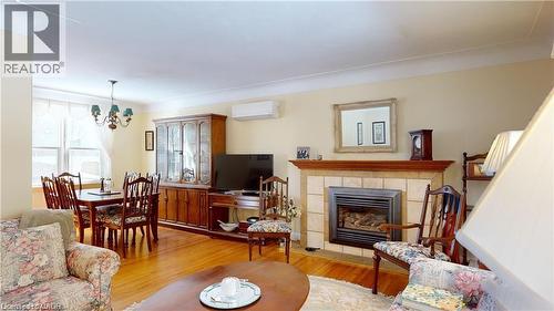 Living space featuring wood-finish flooring and a tiled fireplace with a wood mantel - 919 Montgomery Drive, Ancaster, ON 