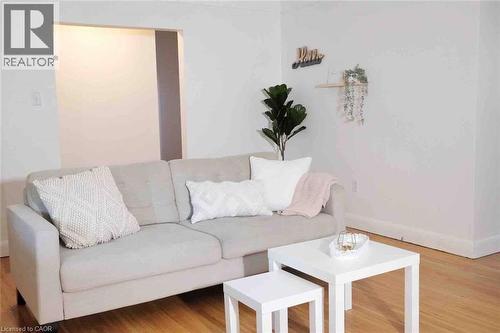 Bright living space featuring warm wood-finish flooring, crisp white walls, and a recessed wall opening - 919 Montgomery Drive, Ancaster, ON 