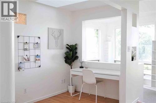 Bright interior space featuring white walls and wood-finish flooring - 919 Montgomery Drive, Ancaster, ON 