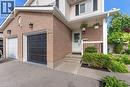 Exterior featuring brick and siding finishes, two garage doors, a covered entry, and mature landscaping - 33 Remple Court, Cambridge, ON 