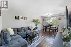 Open-concept living space featuring wood-finish flooring - 