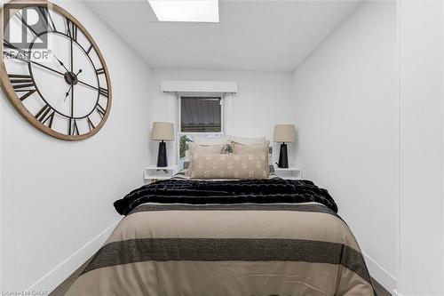 Compact bedroom featuring a window, built-in shelving, and recessed ceiling lighting - 11 Ford Street, Hamilton, ON 