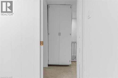 White paneled walls framing a doorway with a brass latch - 11 Ford Street, Hamilton, ON 