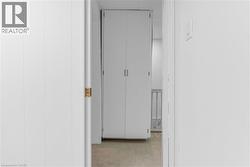 White paneled walls framing a doorway with a brass latch - 