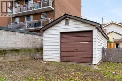 Detached single-car garage featuring a brown sectional door and white siding - 