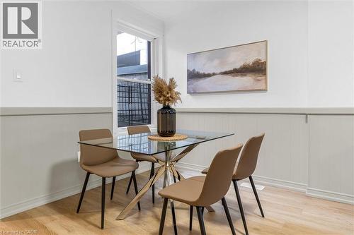 Dining area featuring wood-finish flooring, white walls, and wainscoting - 11 Ford Street, Hamilton, ON 