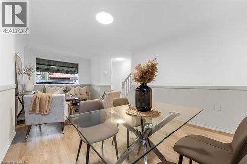 Open-concept living area featuring light wood-finish flooring, white walls with wainscoting, and recessed lighting - 11 Ford Street, Hamilton, ON 