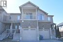 Multi-level townhome exterior featuring light-colored siding and brick accents - 52 Meadowridge Street, Kitchener, ON 